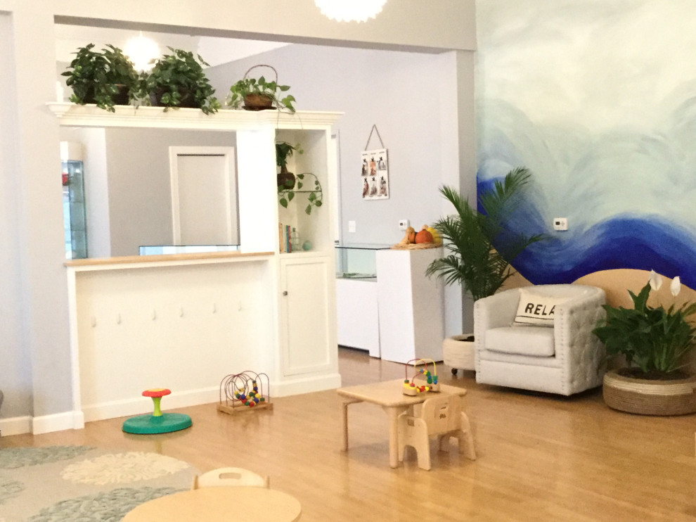 На фото: нейтральная детская с игровой среднего размера в морском стиле с серыми стенами, паркетным полом среднего тона и коричневым полом для ребенка от 1 до 3 лет