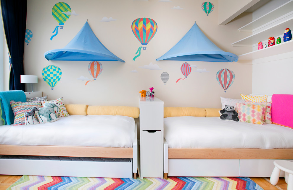 Immagine di una cameretta per bambini da 4 a 10 anni moderna di medie dimensioni con pareti beige e parquet chiaro