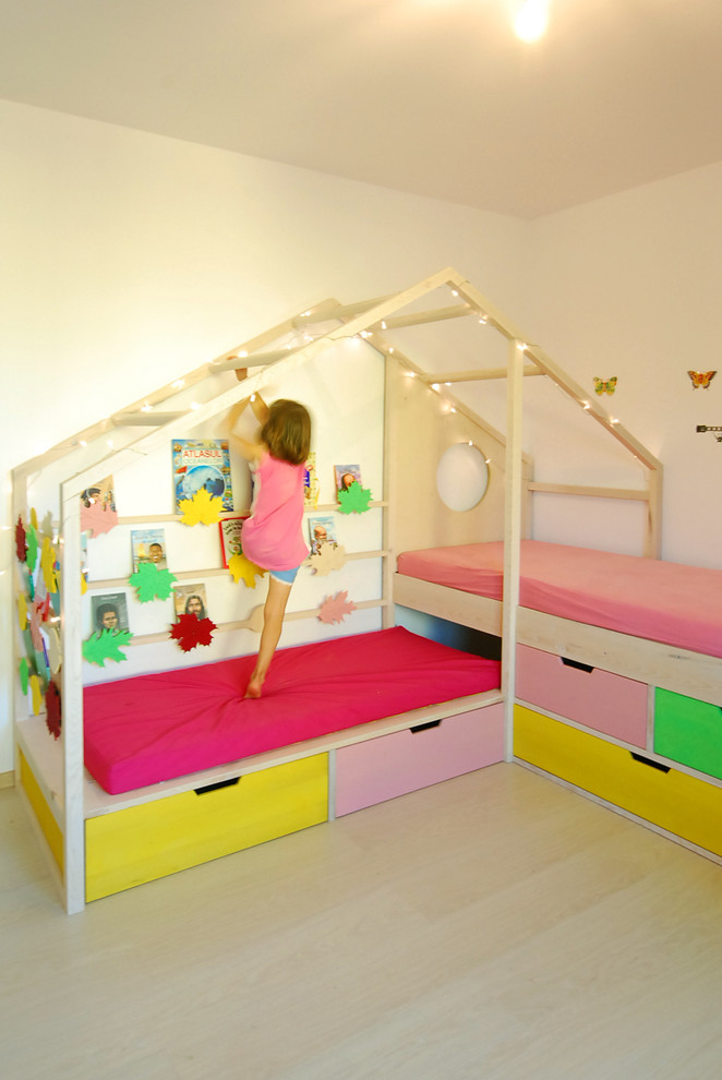 Bild på ett mellanstort funkis flickrum kombinerat med sovrum och för 4-10-åringar, med gula väggar, ljust trägolv och beiget golv