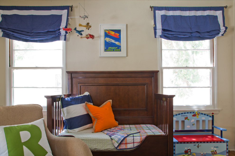 Modelo de dormitorio infantil de 1 a 3 años tradicional de tamaño medio con suelo de madera en tonos medios