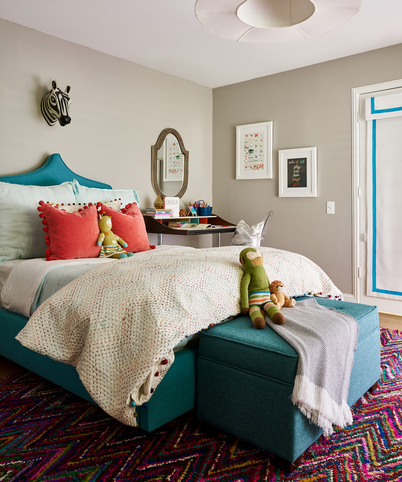 This is an example of a medium sized classic children’s room for girls in Dallas with grey walls and medium hardwood flooring.