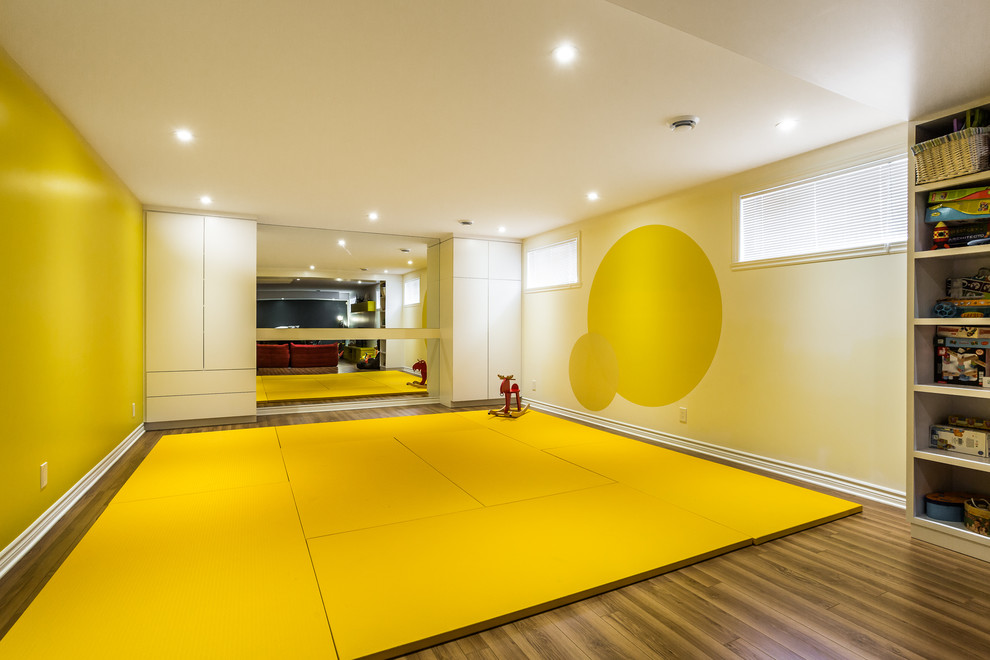 На фото: большая нейтральная детская с игровой в современном стиле с желтыми стенами и желтым полом для ребенка от 4 до 10 лет