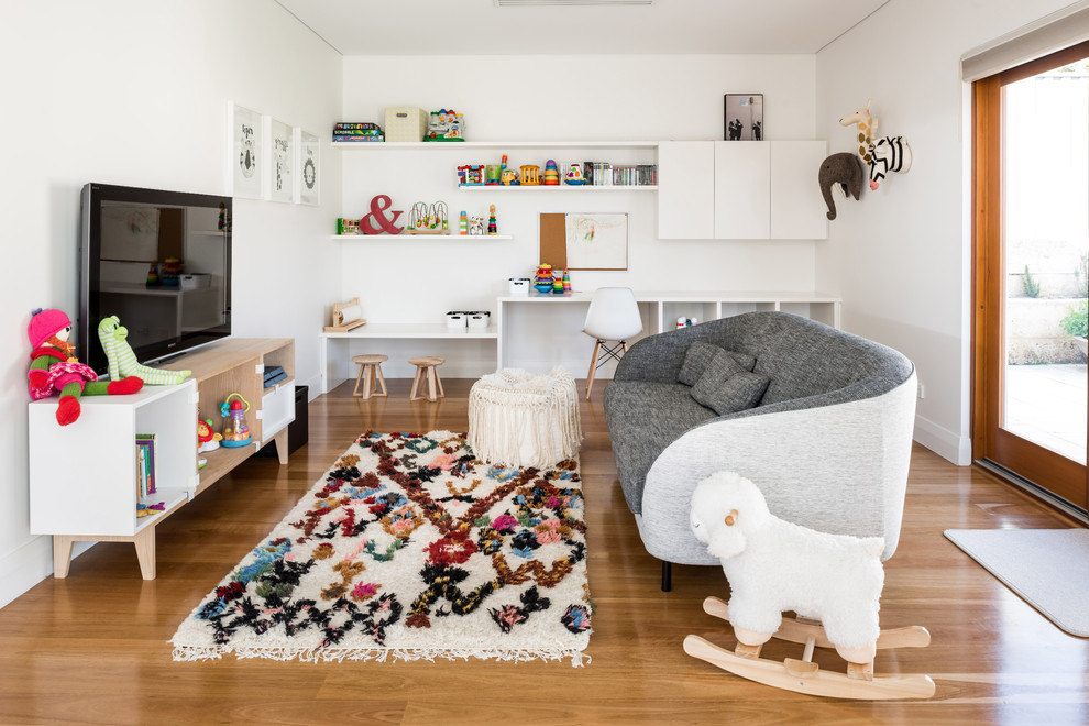 Bild på ett minimalistiskt könsneutralt barnrum kombinerat med lekrum och för 4-10-åringar, med vita väggar, mellanmörkt trägolv och brunt golv