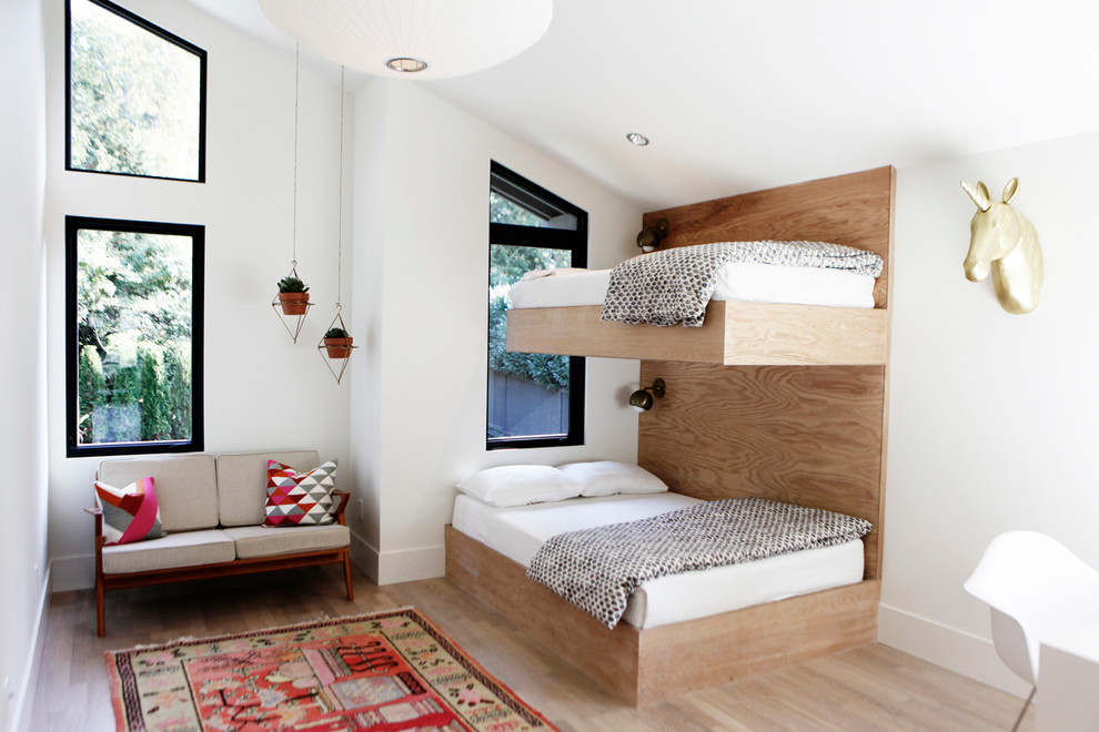 This is an example of a medium sized contemporary gender neutral children’s room in Seattle with white walls, light hardwood flooring and brown floors.
