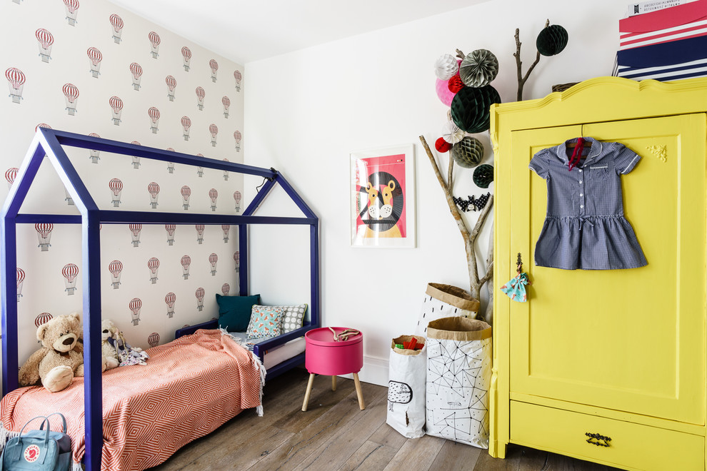 Inredning av ett skandinaviskt flickrum kombinerat med sovrum och för 4-10-åringar, med flerfärgade väggar och ljust trägolv