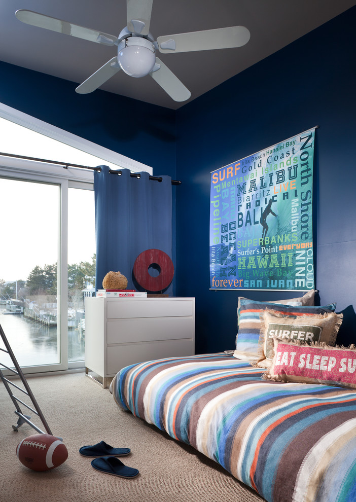 Inspiration for a small nautical teen’s room for boys in New York with blue walls, carpet and beige floors.