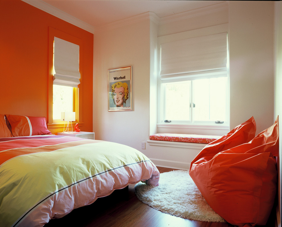 Imagen de dormitorio infantil contemporáneo con suelo de madera oscura y paredes multicolor