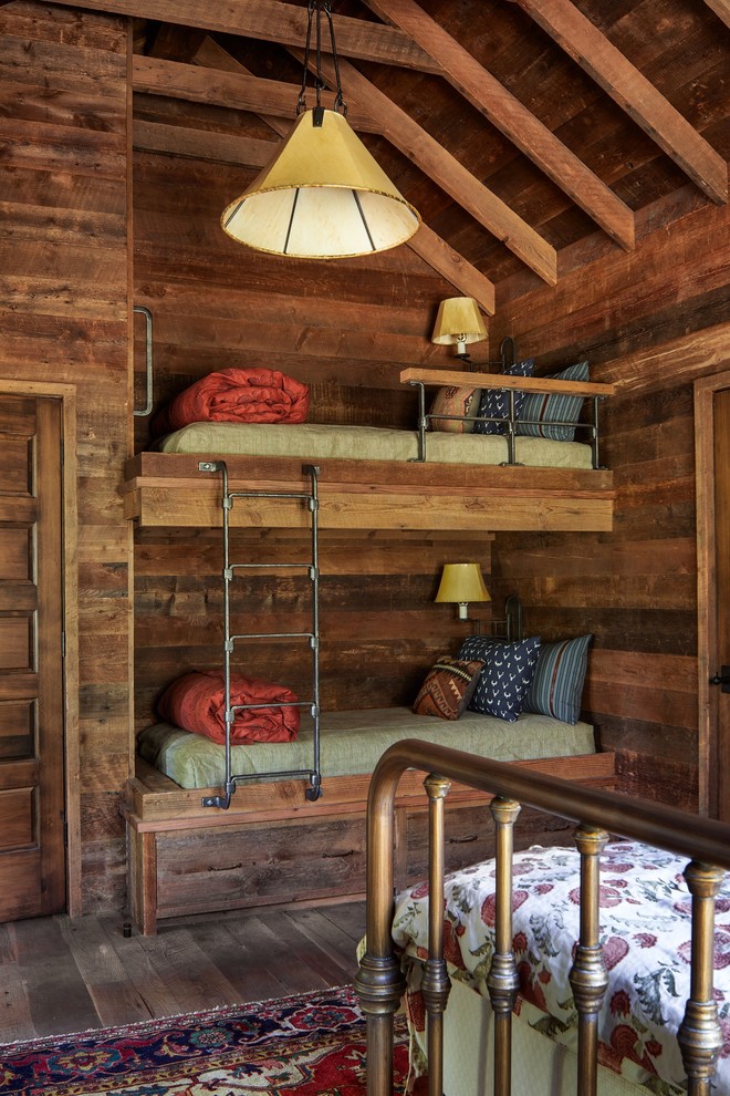 Cette image montre une chambre d'enfant chalet avec un mur marron, un sol marron, parquet foncé et un lit superposé.