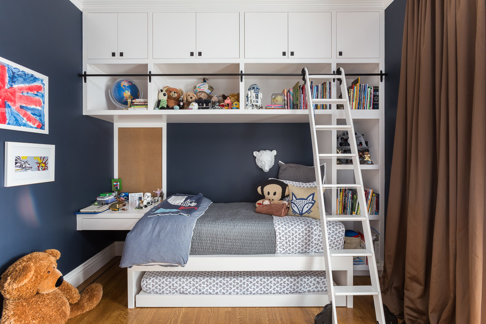 Cette photo montre une chambre d'enfant chic avec un mur bleu et un sol en bois brun.