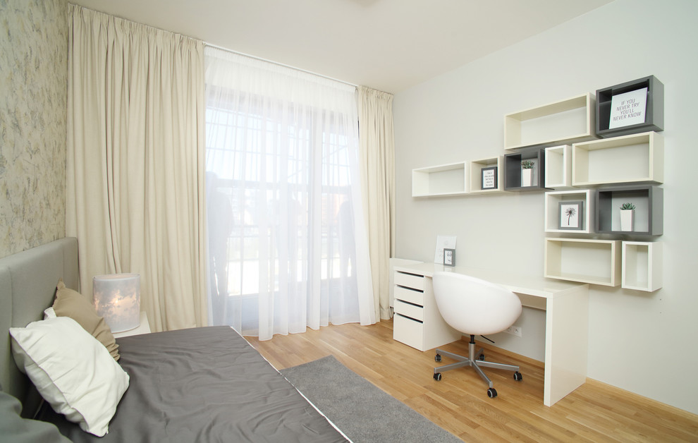 Foto på ett mellanstort funkis könsneutralt tonårsrum kombinerat med skrivbord, med vita väggar och ljust trägolv