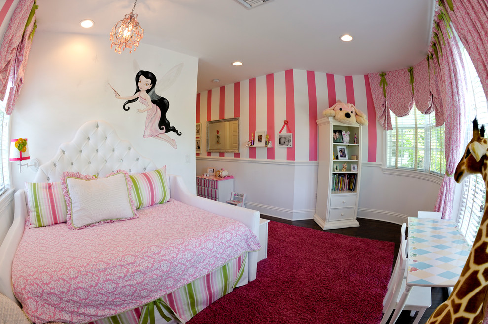 Aménagement d'une chambre d'enfant de 1 à 3 ans victorienne de taille moyenne avec un mur rose et parquet foncé.