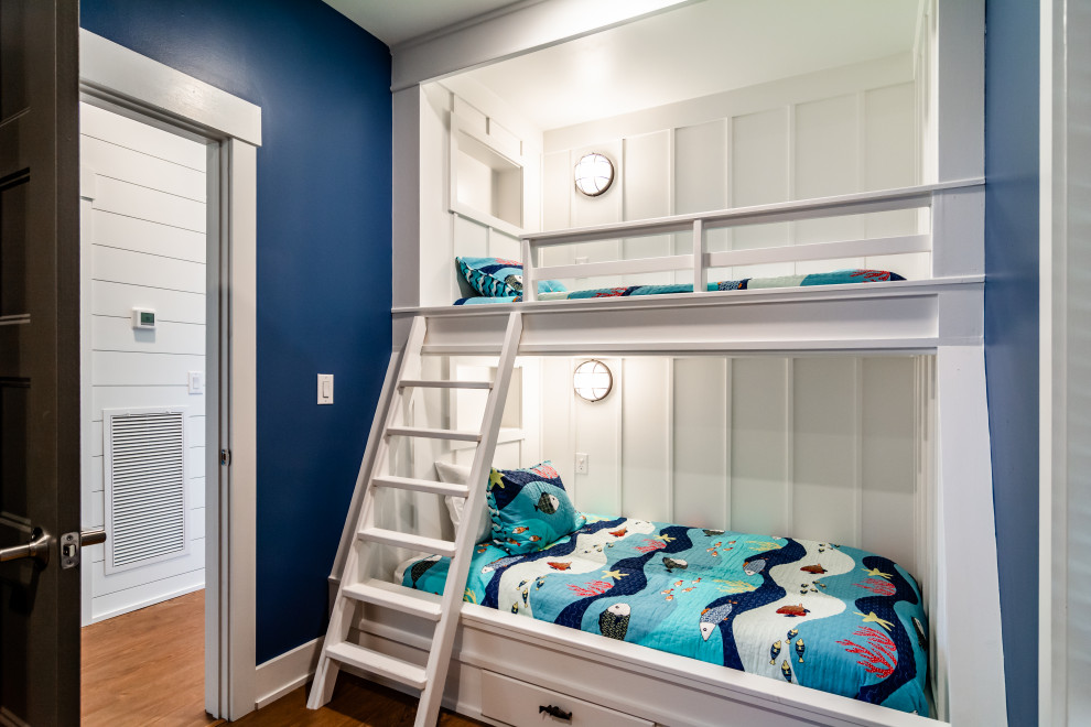 Foto på ett mellanstort maritimt könsneutralt barnrum kombinerat med sovrum och för 4-10-åringar, med blå väggar, mellanmörkt trägolv och brunt golv