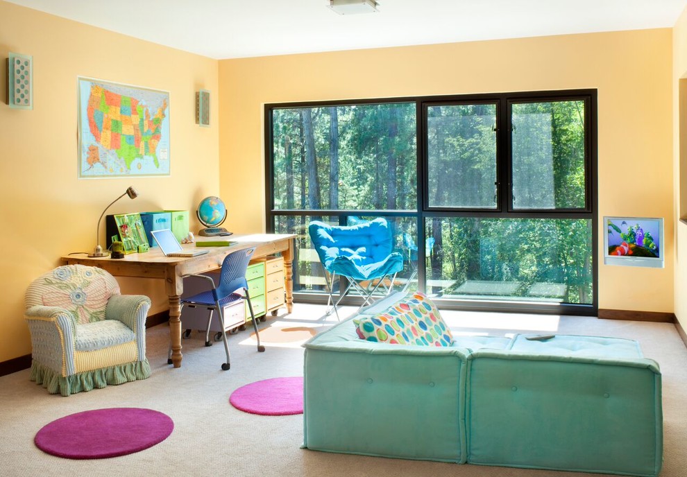 Imagen de habitación infantil unisex actual grande con escritorio, paredes amarillas y moqueta