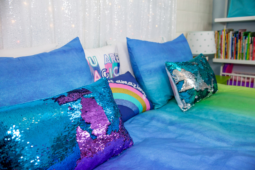 Foto på ett mellanstort flickrum kombinerat med sovrum och för 4-10-åringar, med blå väggar, heltäckningsmatta och flerfärgat golv