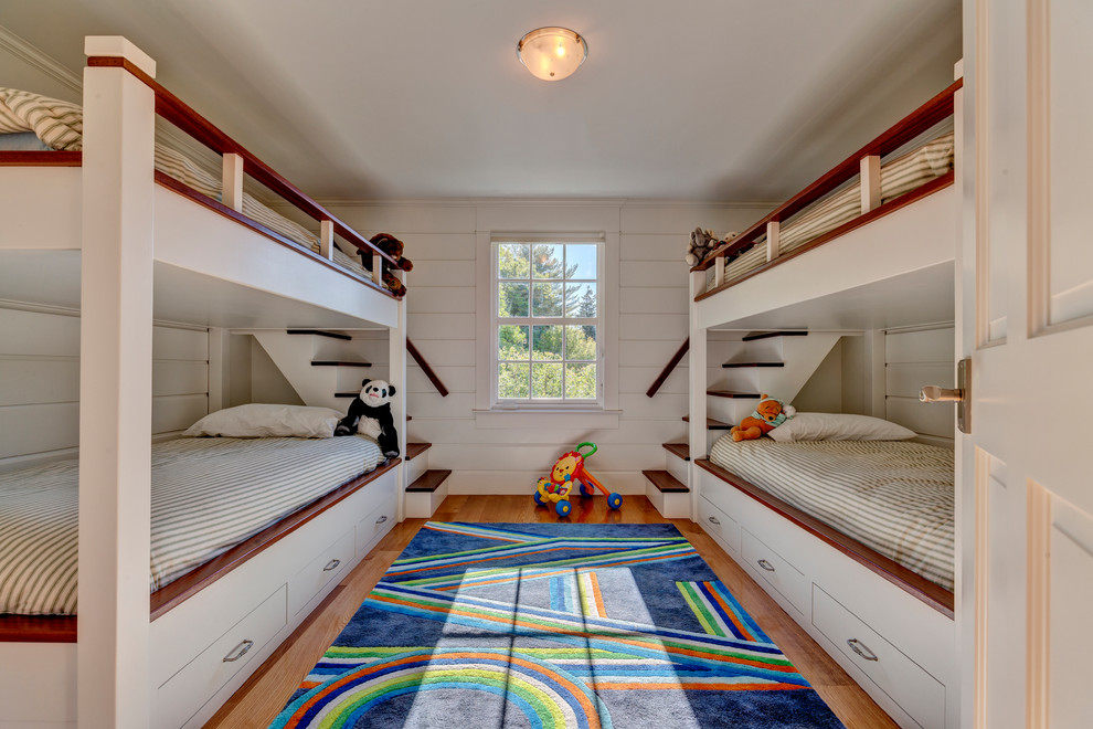Inspiration för klassiska könsneutrala barnrum kombinerat med sovrum, med vita väggar, mellanmörkt trägolv och brunt golv