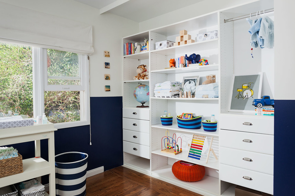 Diseño de dormitorio infantil de 1 a 3 años costero de tamaño medio con suelo de madera en tonos medios y paredes multicolor