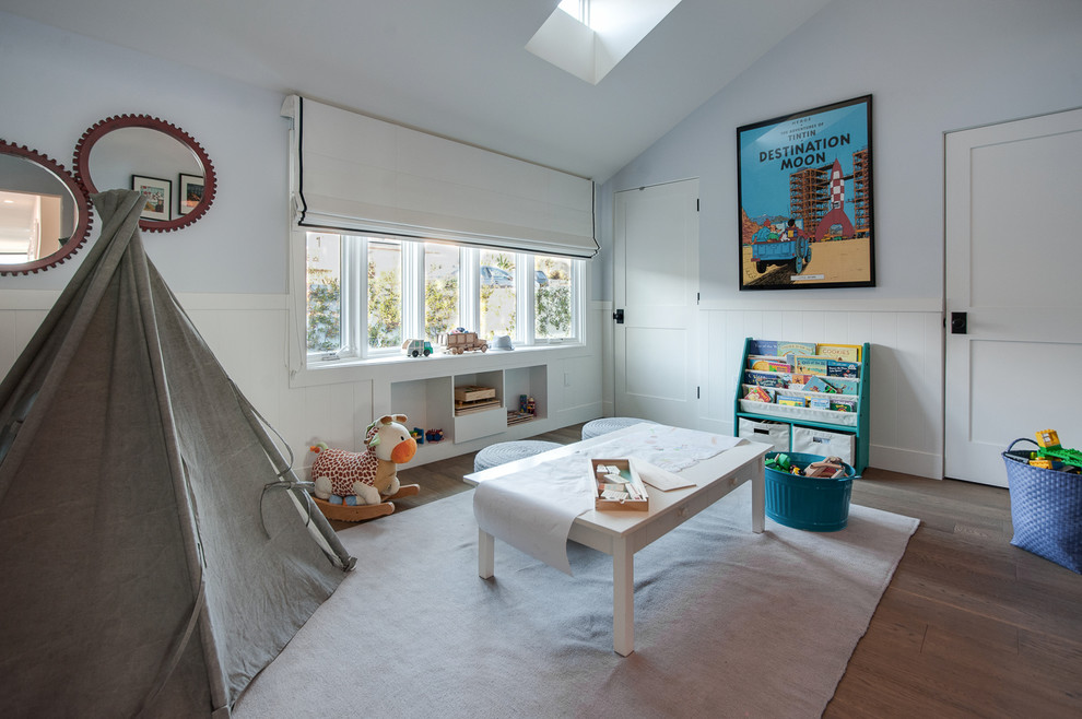 Ispirazione per una cameretta per bambini da 1 a 3 anni stile marino con pareti blu e pavimento in legno massello medio