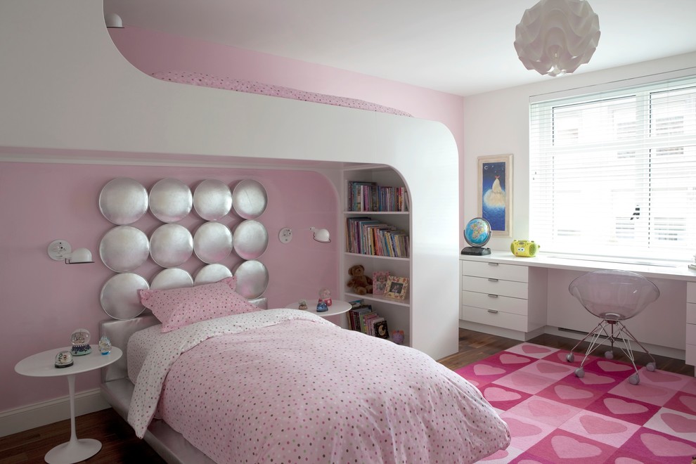 Imagen de dormitorio infantil de 4 a 10 años actual con paredes rosas y suelo de madera oscura