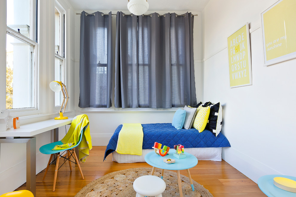 Réalisation d'une chambre d'enfant de 4 à 10 ans nordique de taille moyenne avec un mur blanc et un sol en bois brun.