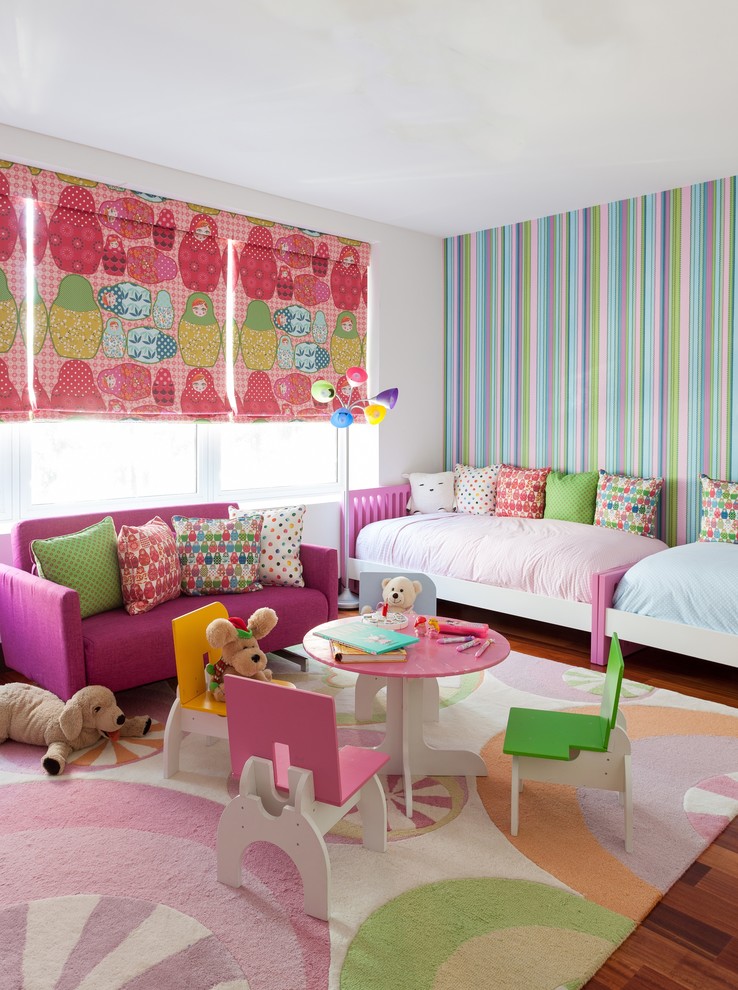 Cette photo montre une chambre d'enfant de 1 à 3 ans tendance de taille moyenne avec un mur blanc et parquet foncé.