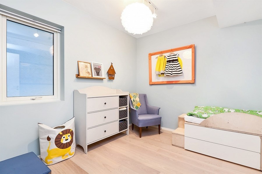 Ejemplo de dormitorio infantil de 1 a 3 años minimalista pequeño con paredes azules y suelo de madera clara