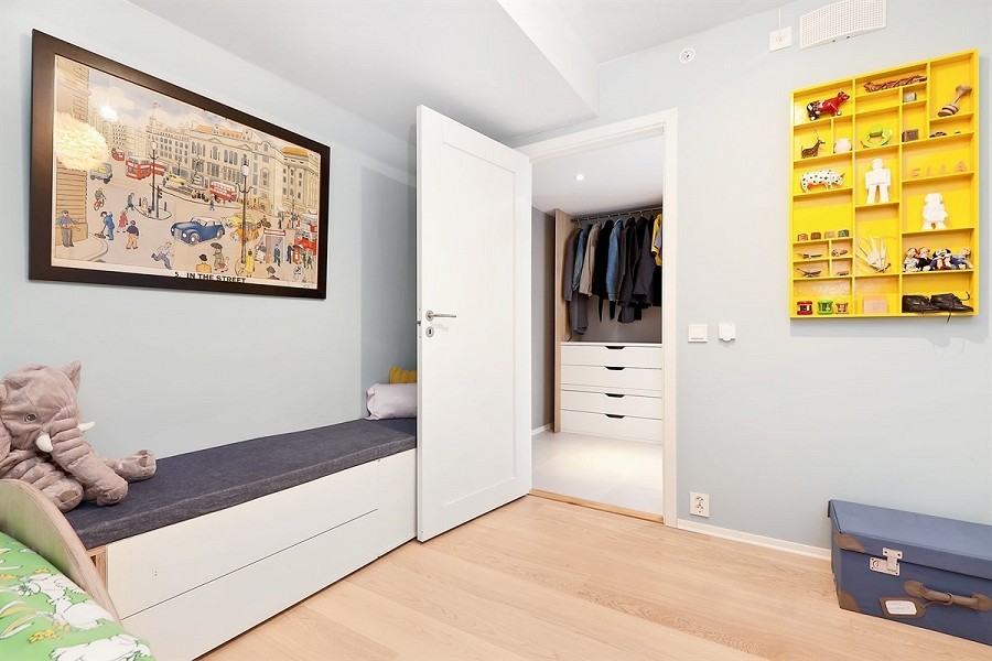 Modelo de dormitorio infantil de 1 a 3 años minimalista pequeño con paredes azules y suelo de madera clara