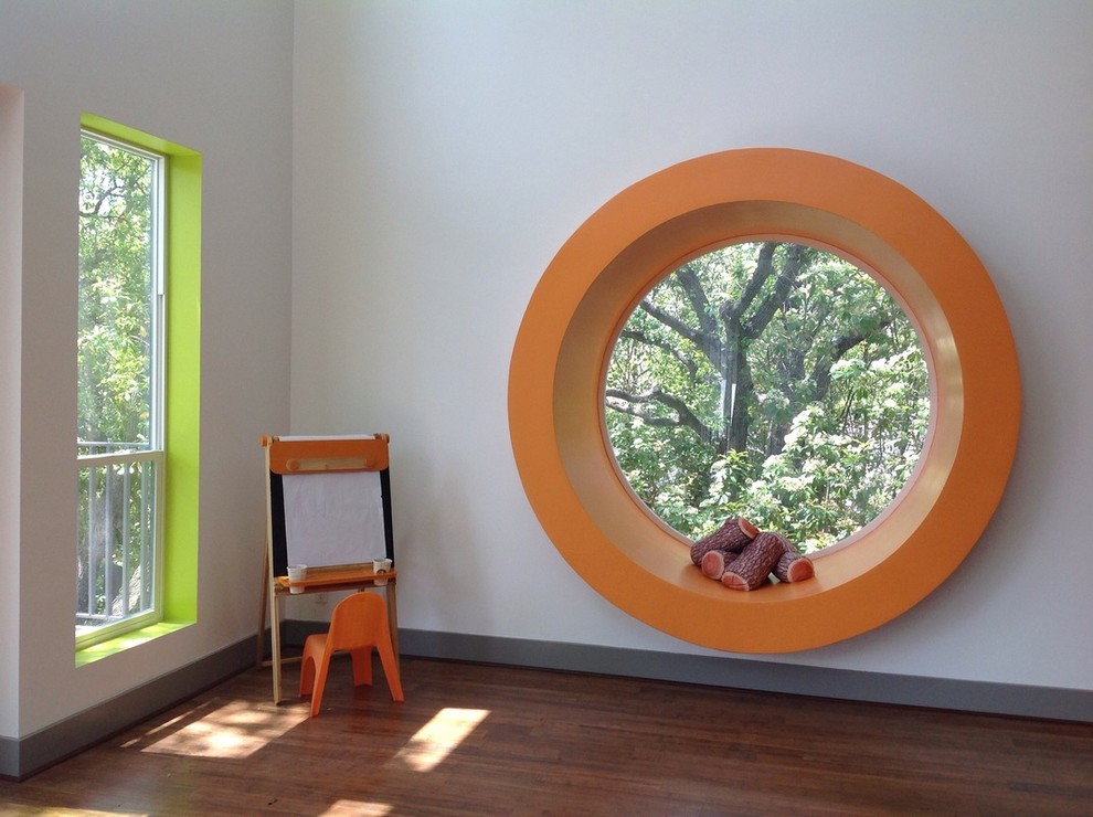 Example of a mid-sized mid-century modern gender-neutral bamboo floor playroom design in Boston with white walls