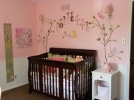 Réalisation d'une chambre de bébé fille tradition de taille moyenne avec un mur rose et parquet foncé.