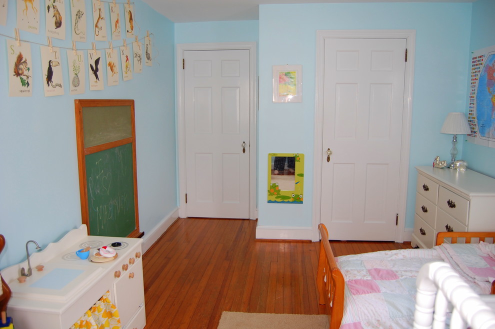 This is an example of a traditional toddler’s room for girls in Philadelphia with blue walls and medium hardwood flooring.
