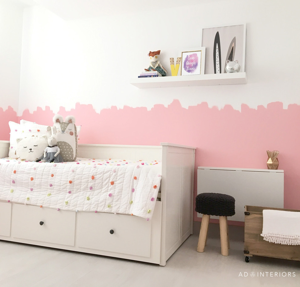 Immagine di una cameretta per bambini da 1 a 3 anni design di medie dimensioni con pareti rosa e pavimento in gres porcellanato