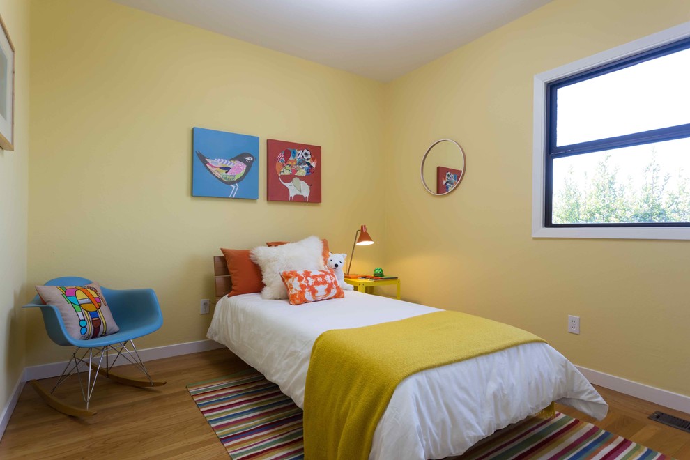 Bild på ett mellanstort retro könsneutralt barnrum kombinerat med sovrum och för 4-10-åringar, med gula väggar och heltäckningsmatta