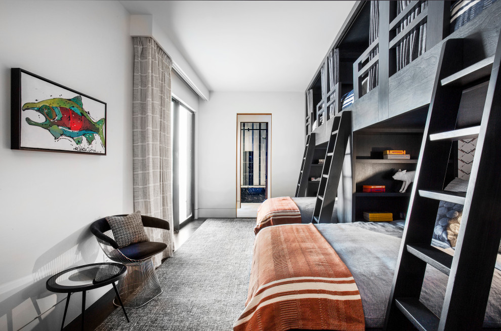 Cette photo montre une chambre d'enfant tendance avec un mur blanc, parquet foncé, un sol marron et un lit superposé.