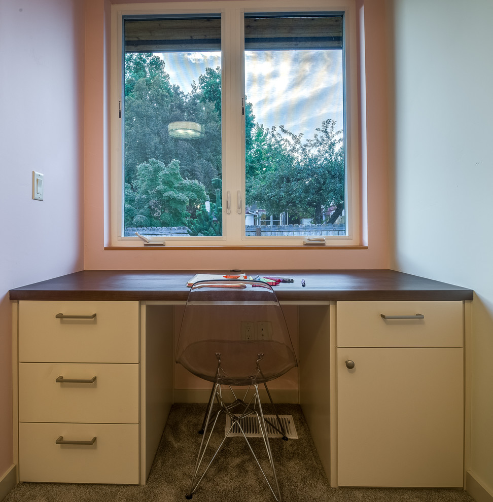 Retro inredning av ett mellanstort tonårsrum kombinerat med skrivbord, med grå väggar, heltäckningsmatta och grått golv