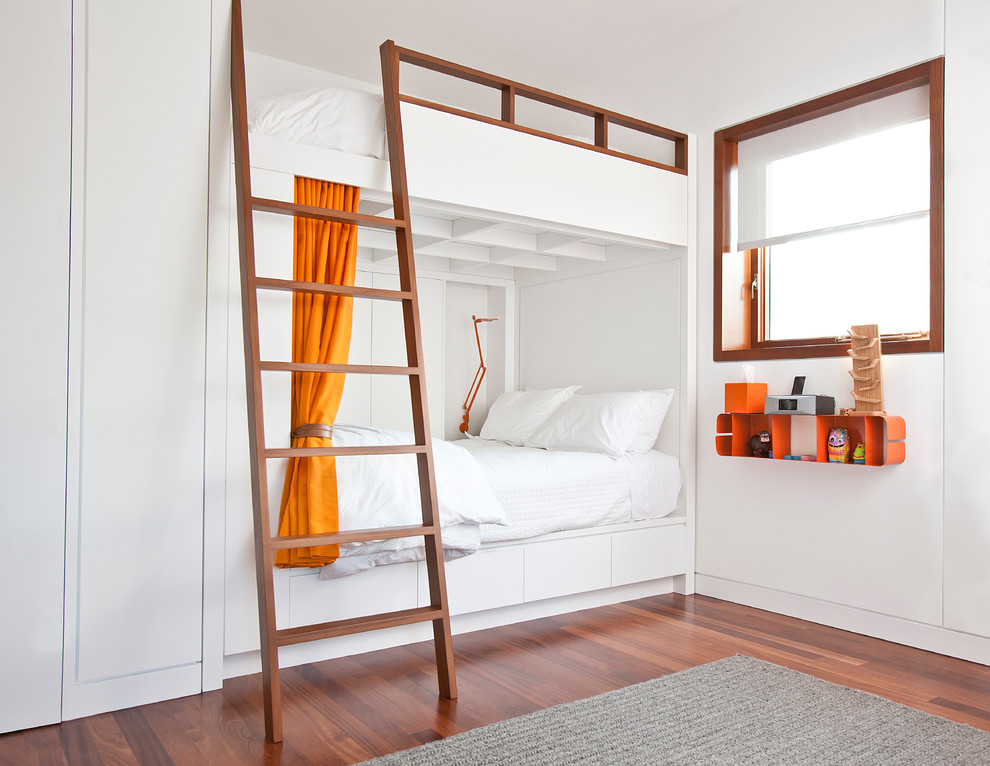 Imagen de dormitorio infantil de 4 a 10 años urbano con paredes blancas, suelo de madera en tonos medios y suelo marrón