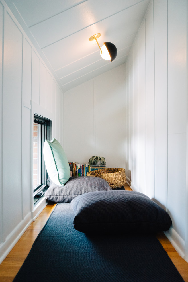 Imagen de habitación infantil unisex retro con paredes blancas y suelo de madera en tonos medios