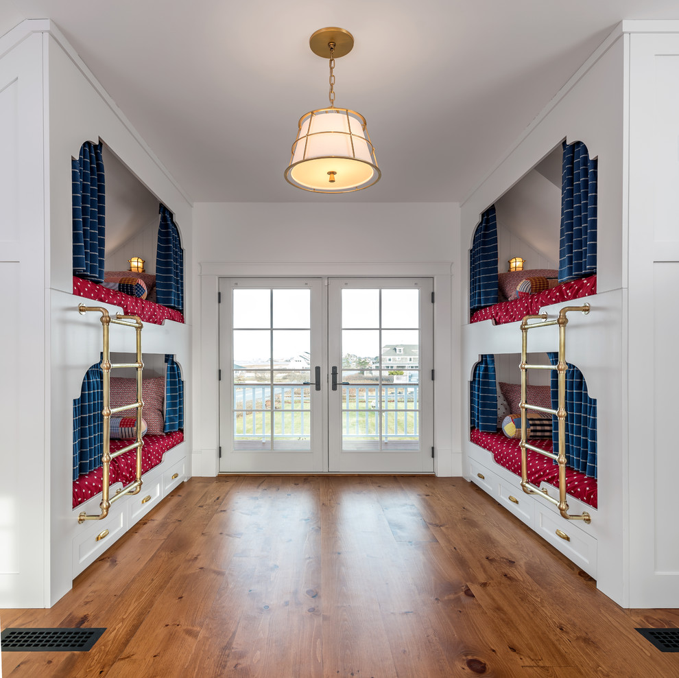 Photo of a nautical gender neutral children’s room in Portland Maine with white walls and medium hardwood flooring.