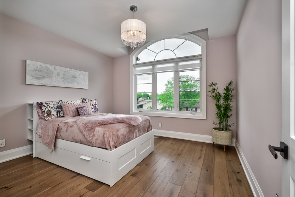 Ejemplo de dormitorio infantil de 1 a 3 años tradicional de tamaño medio con paredes rosas, suelo de madera clara y suelo beige