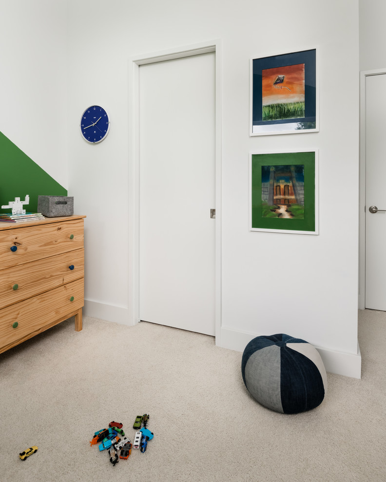 Immagine di una piccola cameretta per bambini da 4 a 10 anni nordica con pareti bianche, moquette e pavimento beige