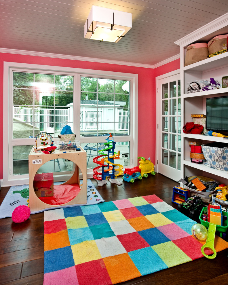 Aménagement d'une petite chambre d'enfant classique avec un mur rose, parquet foncé et un sol marron.
