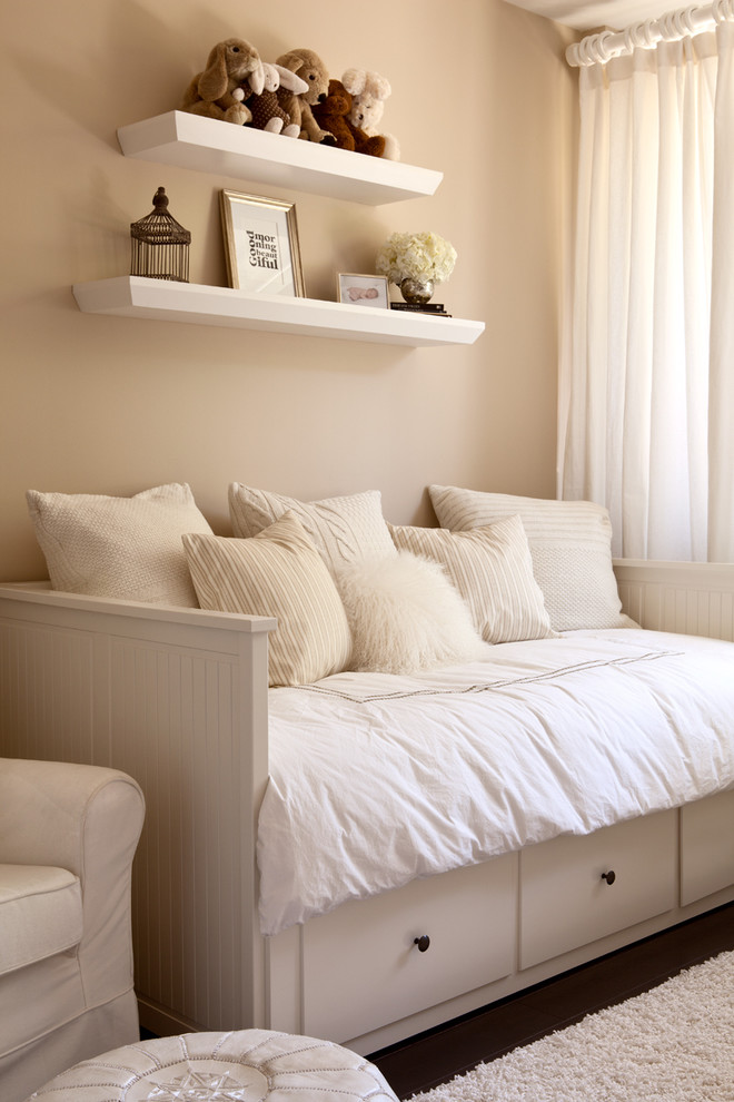 Cette image montre une chambre neutre traditionnelle avec un mur beige et parquet foncé.