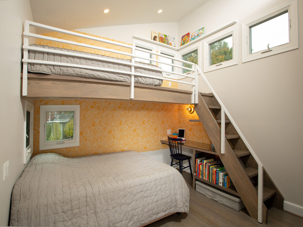 На фото: нейтральная детская среднего размера в современном стиле с спальным местом, серыми стенами и коричневым полом для ребенка от 4 до 10 лет с