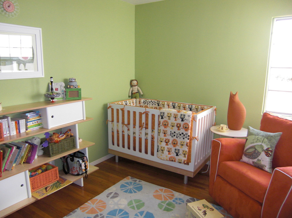 Inspiration pour une chambre d'enfant de 1 à 3 ans de taille moyenne avec un sol en bois brun et un mur vert.