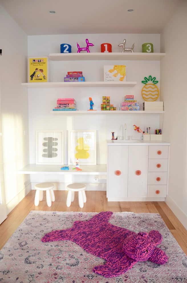 Foto di una cameretta per bambini da 4 a 10 anni moderna di medie dimensioni con pareti bianche, parquet chiaro e pavimento beige