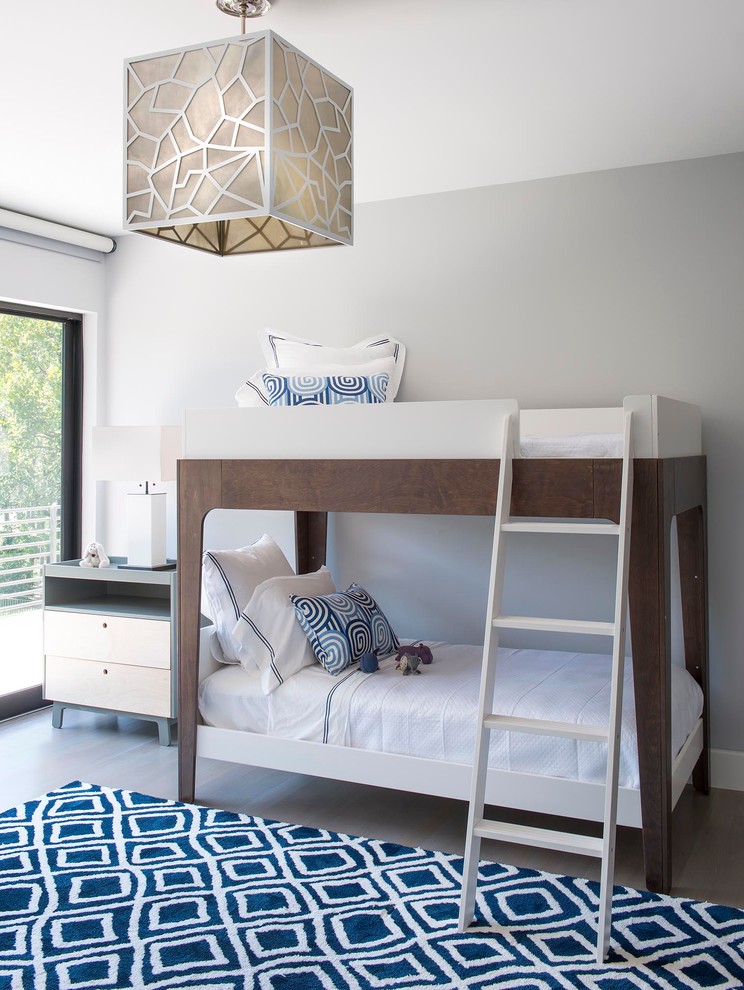 Exempel på ett modernt pojkrum kombinerat med sovrum, med grå väggar och mellanmörkt trägolv
