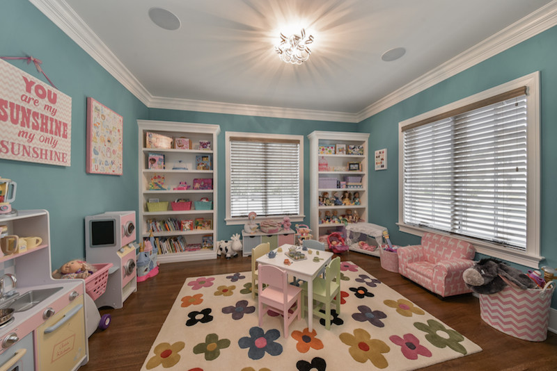 Imagen de dormitorio infantil de 1 a 3 años de estilo americano de tamaño medio con paredes azules y suelo de madera oscura