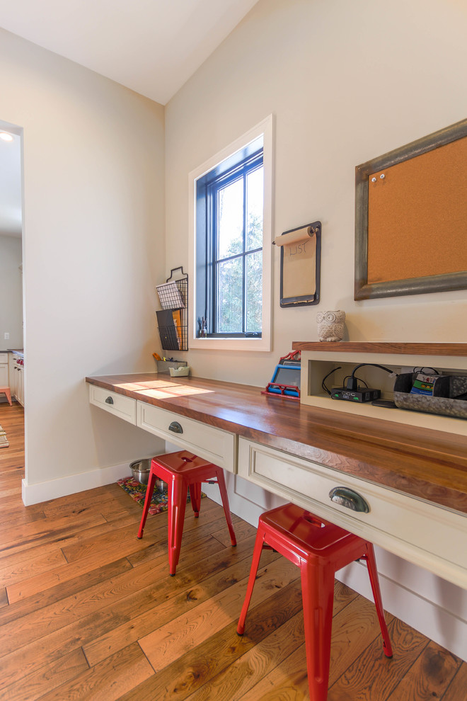 Modelo de habitación infantil unisex de 4 a 10 años de estilo de casa de campo pequeña con escritorio, suelo de madera en tonos medios y paredes grises