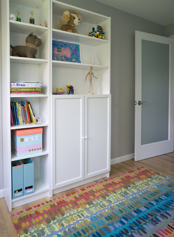 Exempel på ett litet klassiskt könsneutralt barnrum kombinerat med sovrum och för 4-10-åringar, med flerfärgade väggar och ljust trägolv