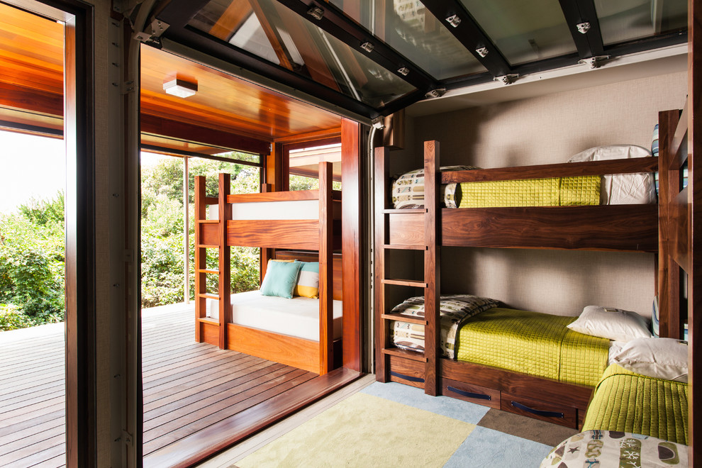 Exempel på ett mellanstort modernt könsneutralt barnrum kombinerat med sovrum och för 4-10-åringar, med beige väggar, heltäckningsmatta och flerfärgat golv