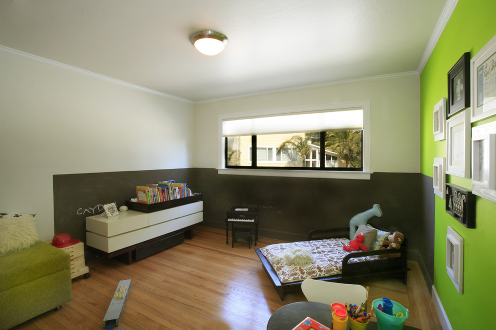 Inspiration för moderna könsneutrala småbarnsrum kombinerat med lekrum, med mellanmörkt trägolv och flerfärgade väggar