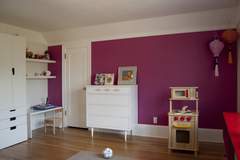 Foto på ett mellanstort funkis flickrum kombinerat med lekrum och för 4-10-åringar, med mellanmörkt trägolv och rosa väggar